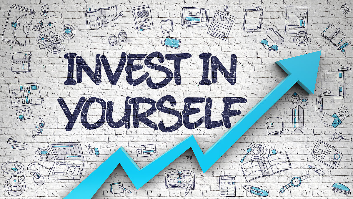 Aufschrift invest in yourself auf einer Wand